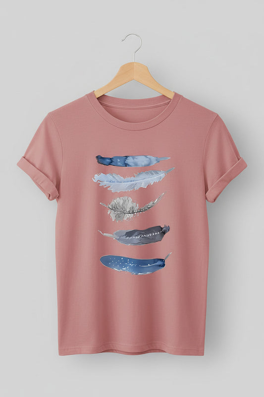 Pink t-shirt with abstract blue designs on a hanger against a denim background