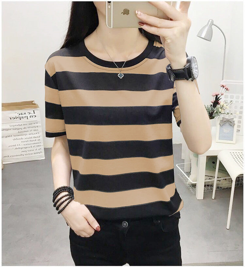 Person wearing a black and beige striped shirt in a room.