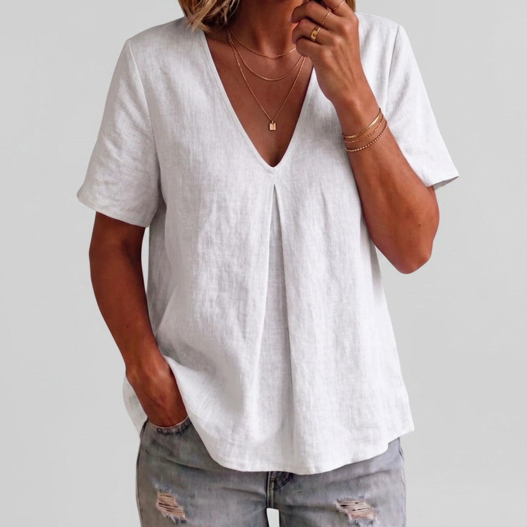 Person wearing a white t-shirt and ripped jeans indoors.