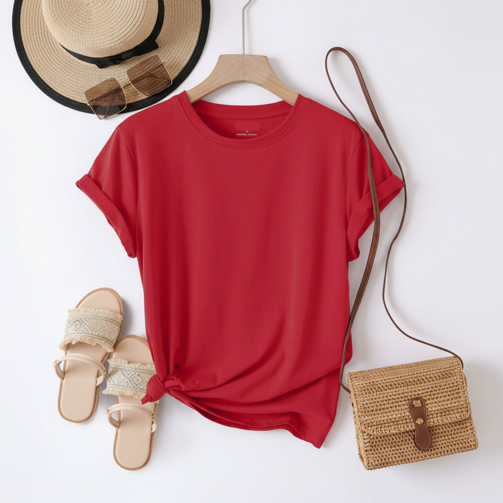 Red t-shirt on a hanger with sandals, hat, and bag on a white background