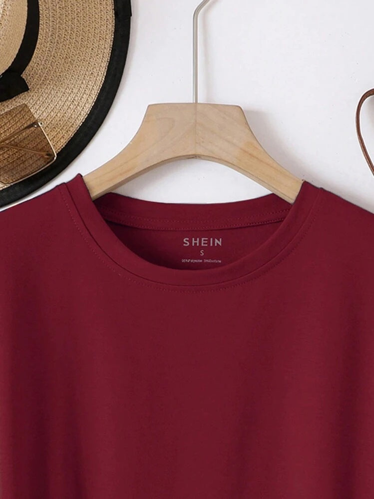 Maroon shirt on a wooden hanger with 'SHEIN' label, hat in the background