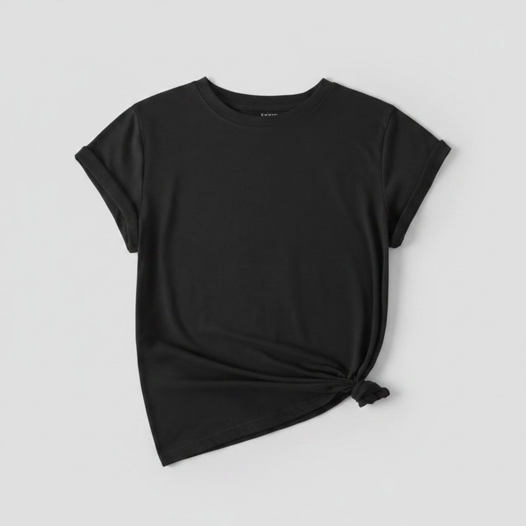 Black t-shirt with white sneakers and denim shorts on a textured surface