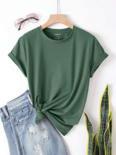 Green t-shirt with a knot, blue jeans, and sunglasses on a white background