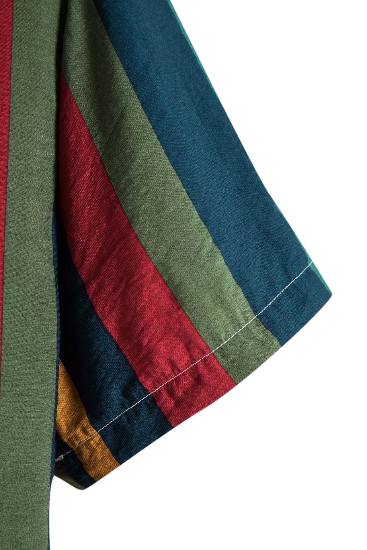 Close-up of a striped fabric with green, red, and blue colors on a white background