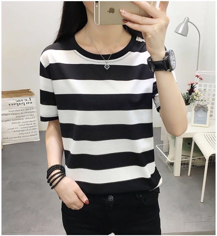 Person wearing a black and white striped shirt in a room setting.