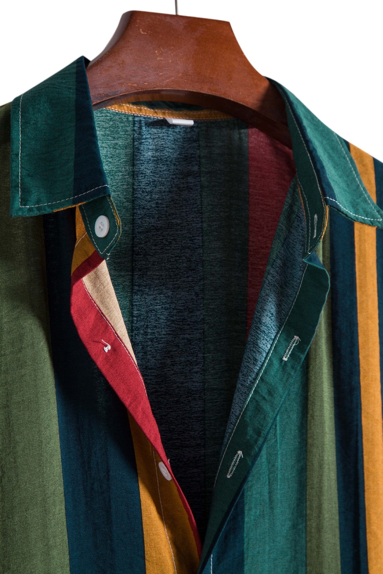 Colorful striped shirt on a hanger with a white background