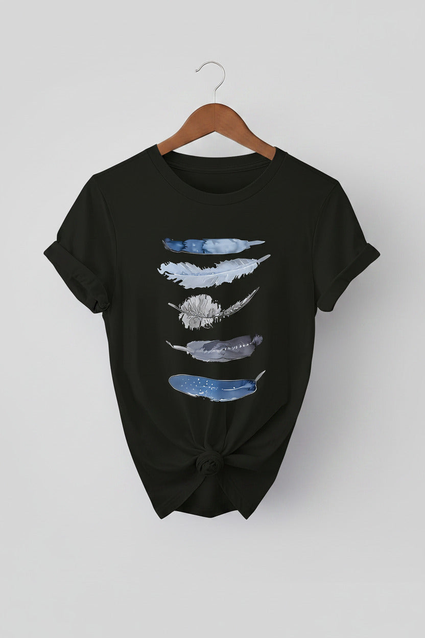Black t-shirt with feather design on a hanger against a denim background