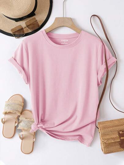 Pink t-shirt with a hat, sandals, and bag on a white background