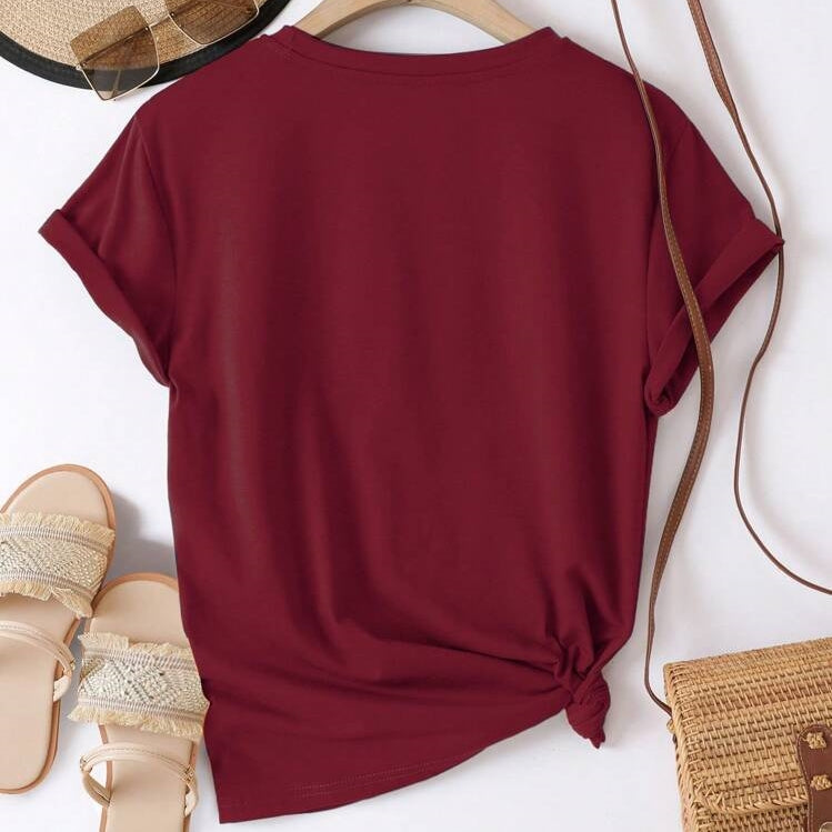 Maroon t-shirt on a white background with sandals and a bag.