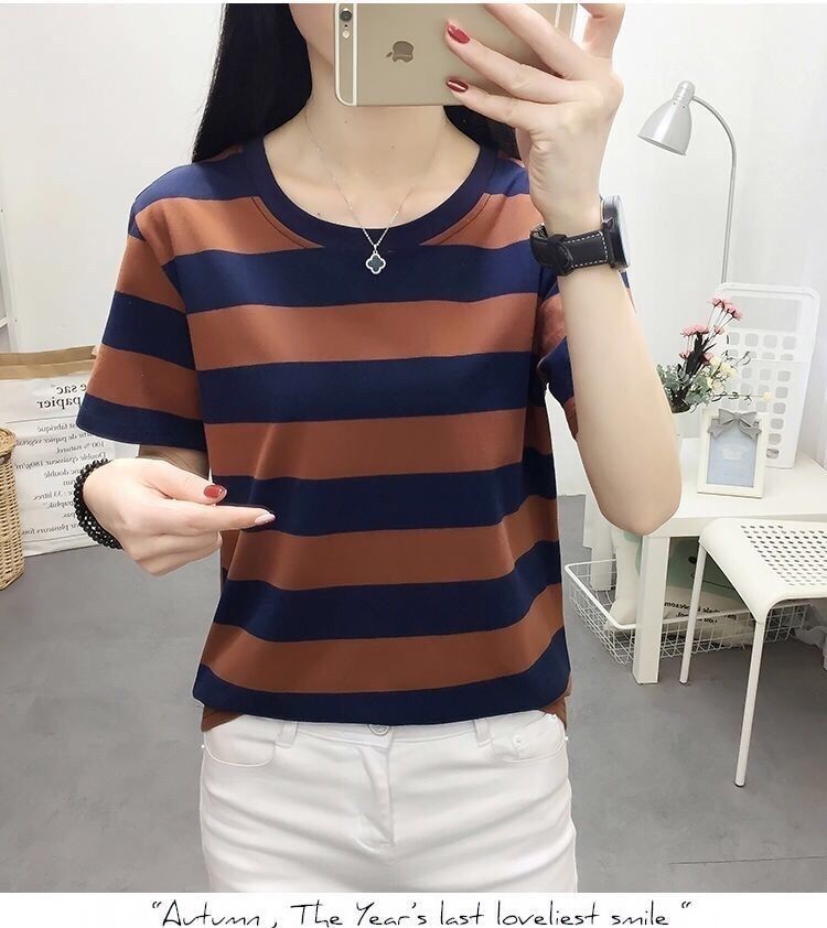 Person wearing a blue and brown striped shirt taking a mirror selfie.