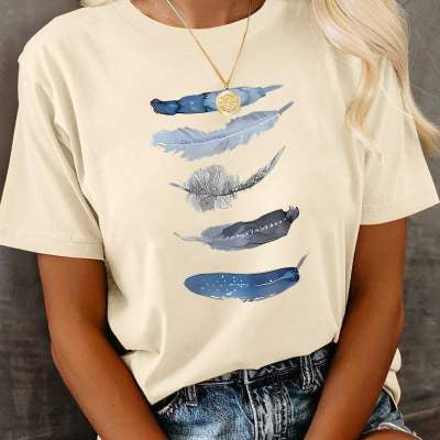 Person wearing a beige t-shirt with blue feather design against a gray background